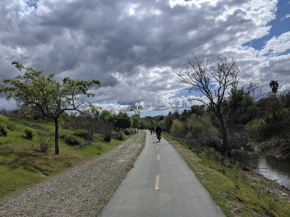 The paved Los Gatos Creek Trail under a cloudy sky