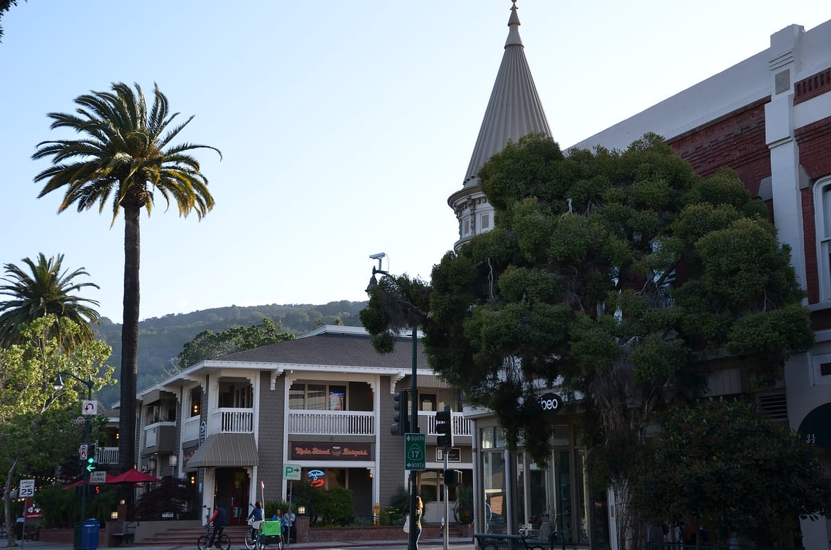 The corner of Main Street and Santa Cruz Avenue, with palms and the turret of the La Cañada Building