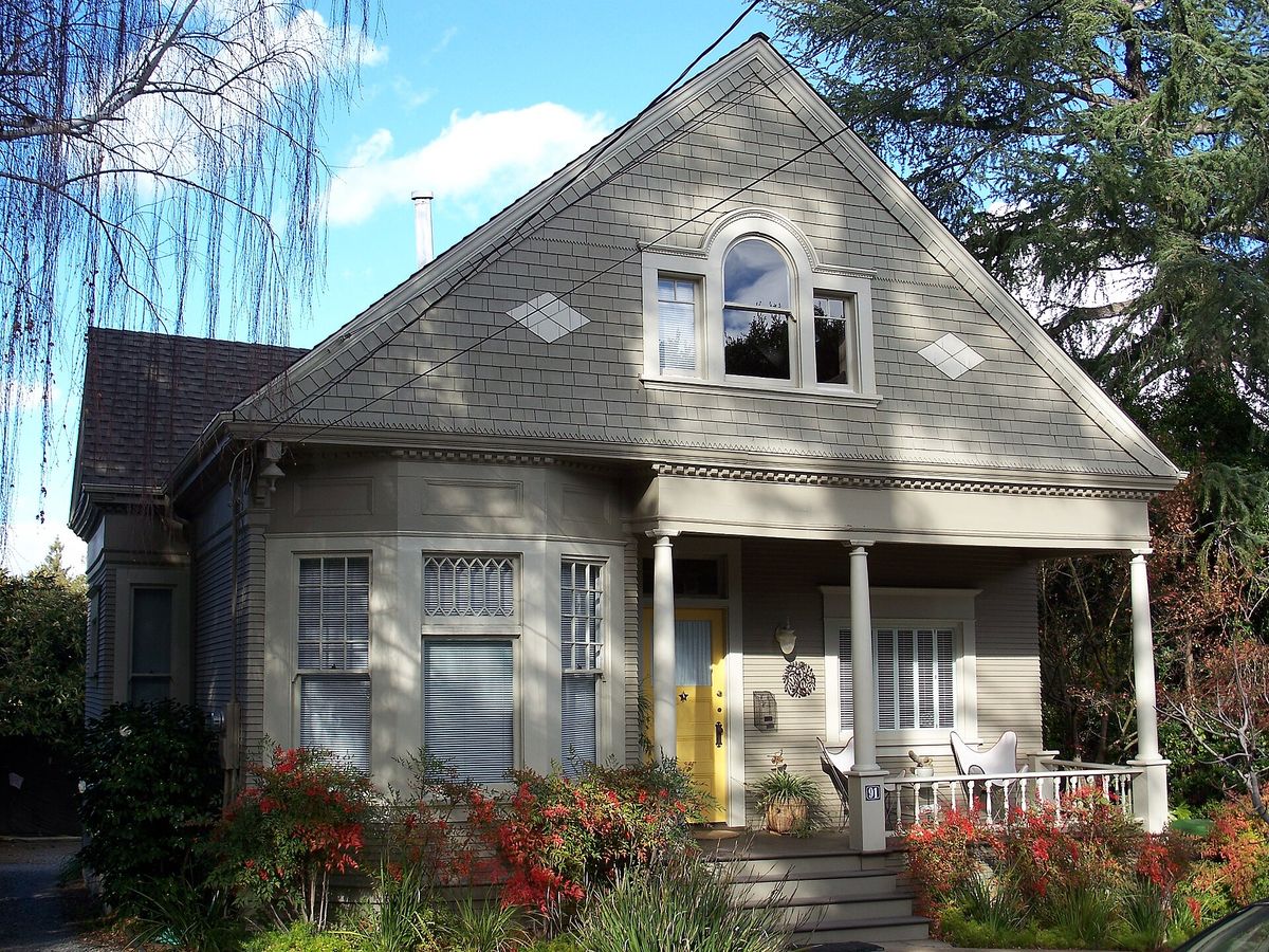 A gabled Victorian house with a flower garden on Fairview Plaza