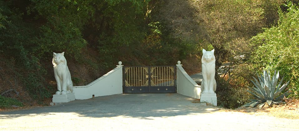 The two white cat statues at the gate of the Cats estate